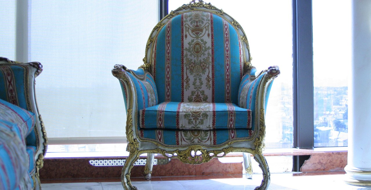 blue and gold striped chair in front of a window