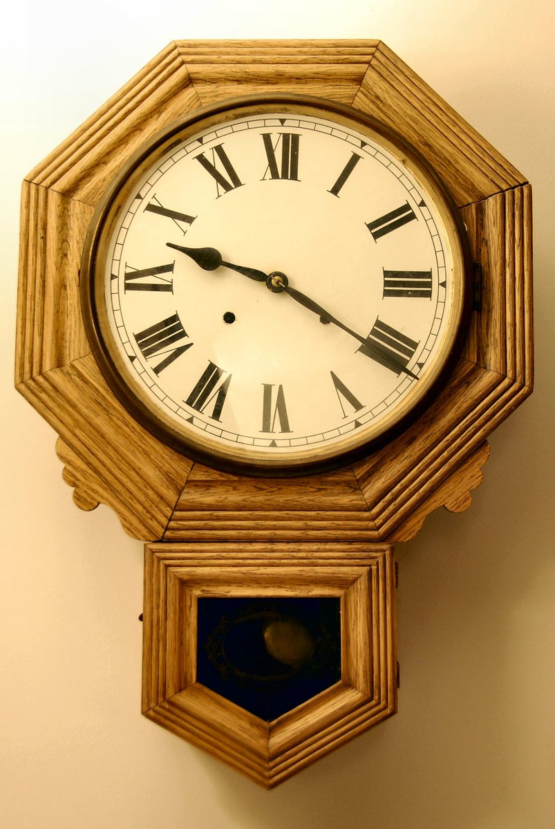 an antique clock is mounted on the wall