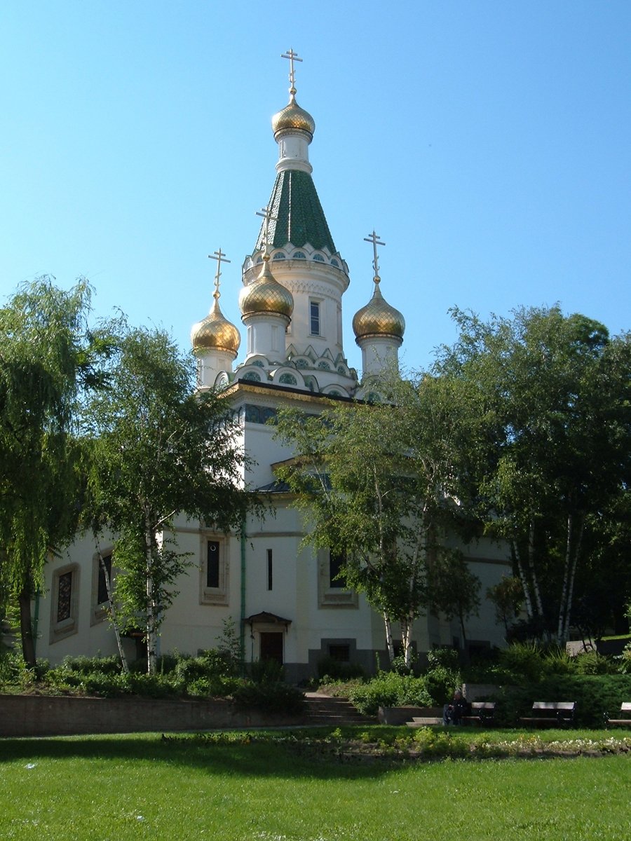 a very tall white building with some golden domes