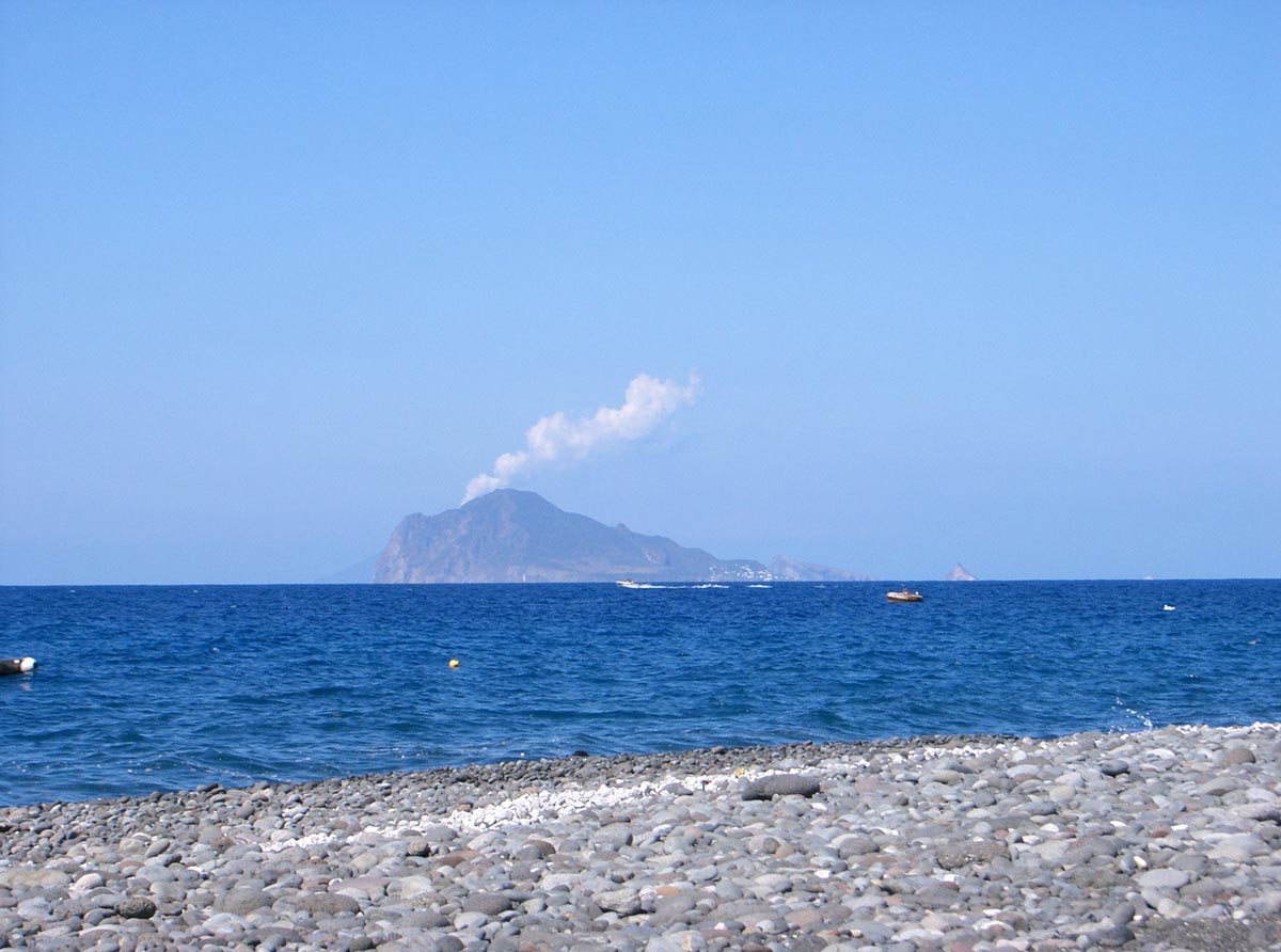 the view of a mountain with a blue ocean