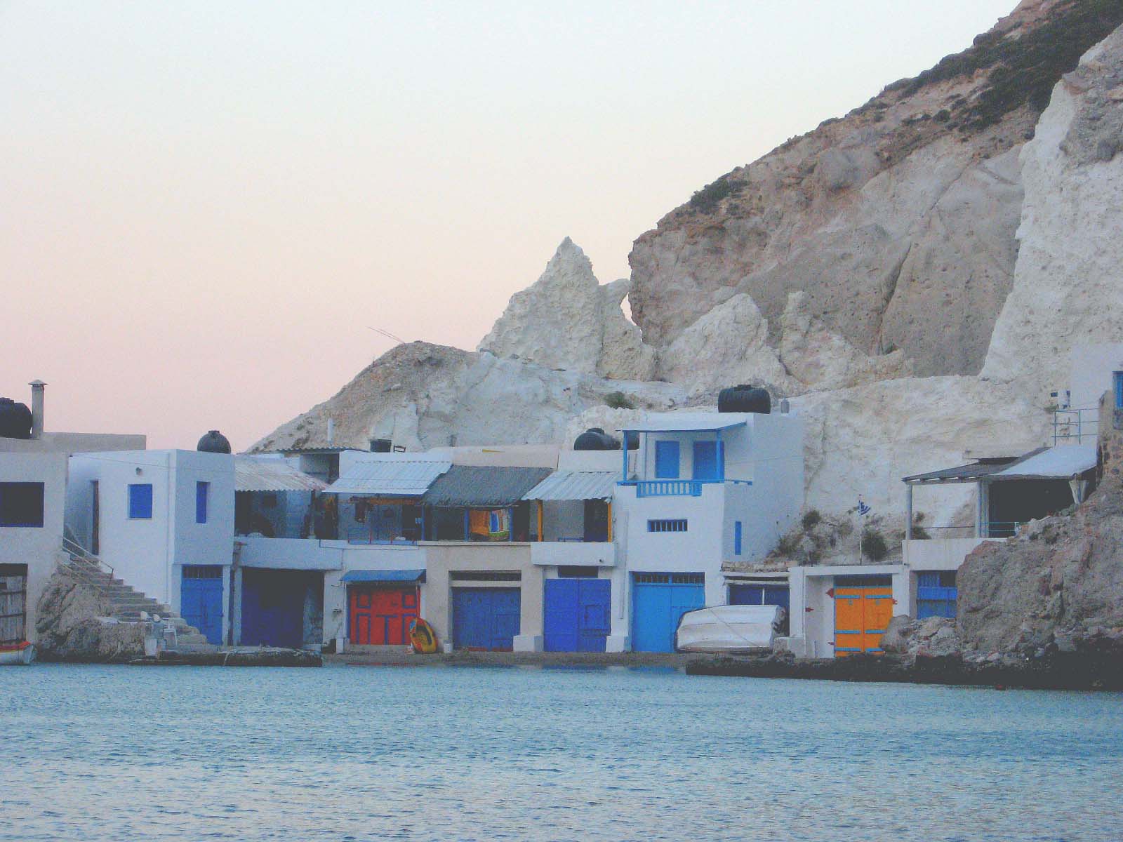 the white houses has multiple doors and are near the water