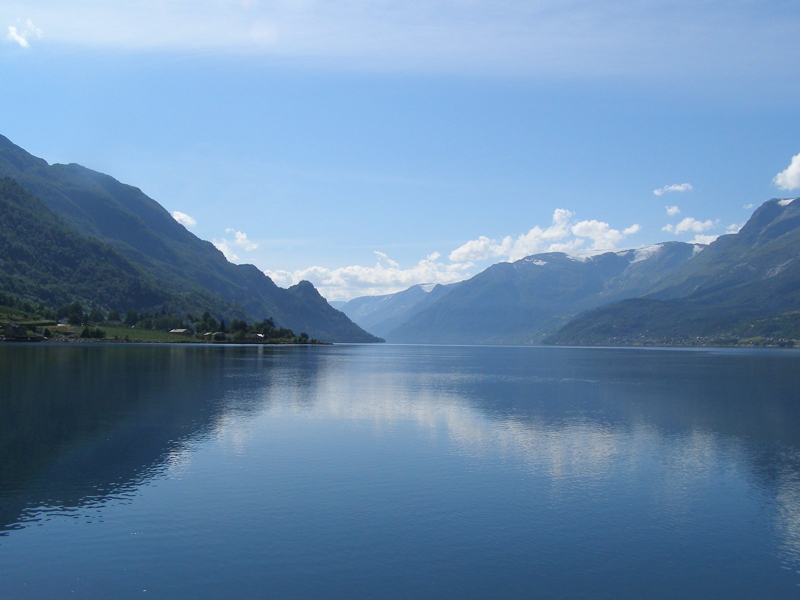 a lake with hills and trees on the other side