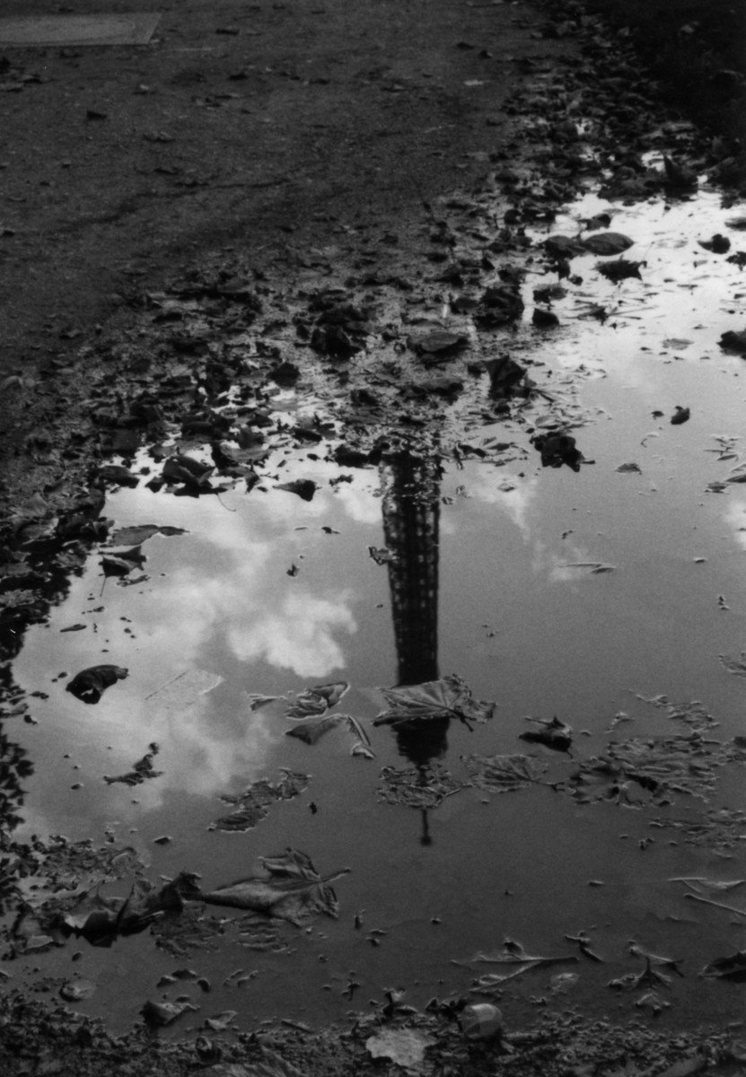 black and white image of a buoy with reflection in water