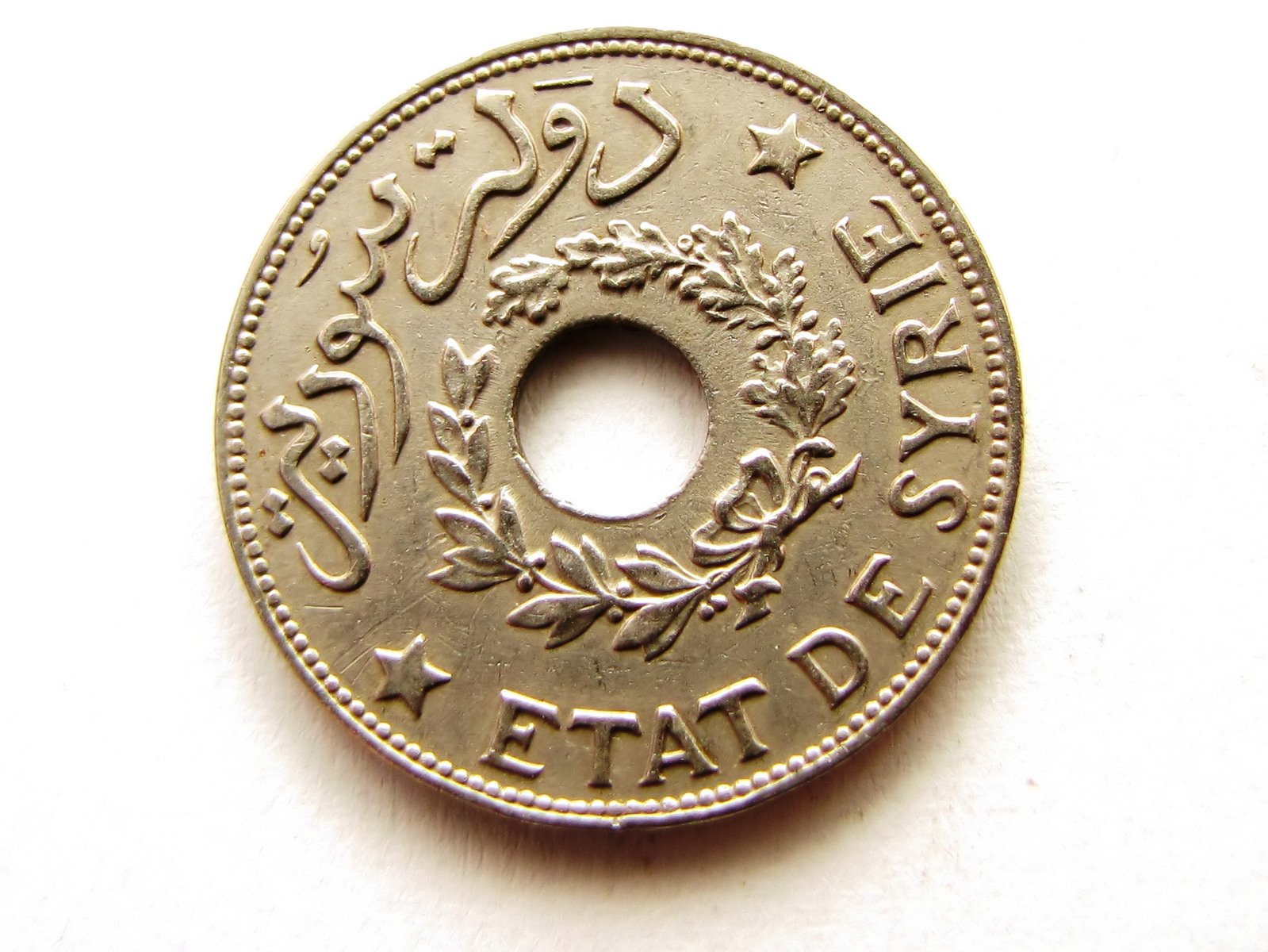 a 1 pound coin is shown with arabic writing on it