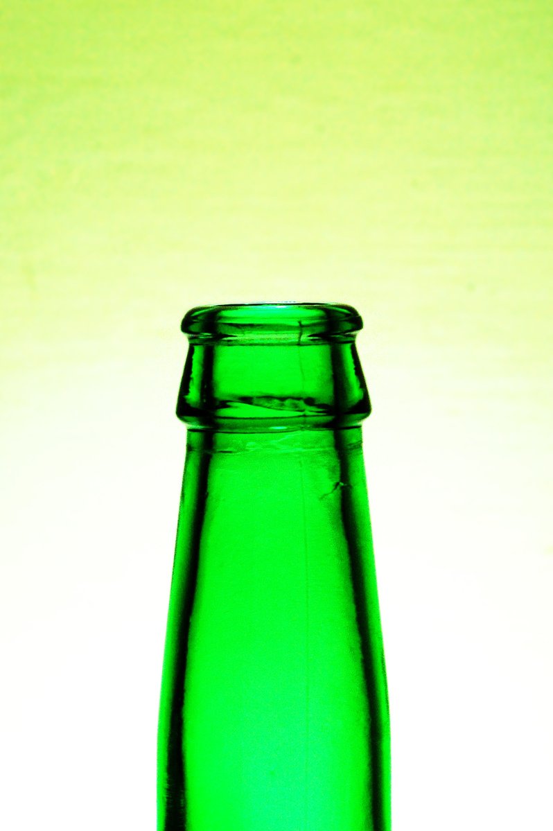 an empty green glass bottle on a white background