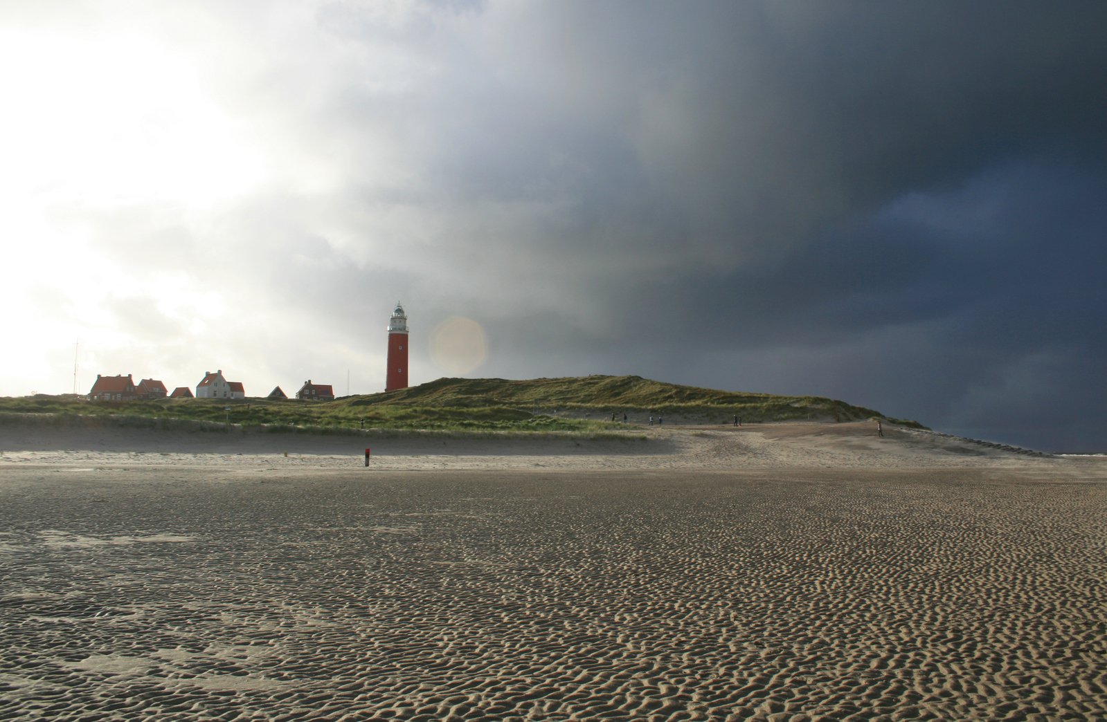 a red lighthouse and a light house near the shore