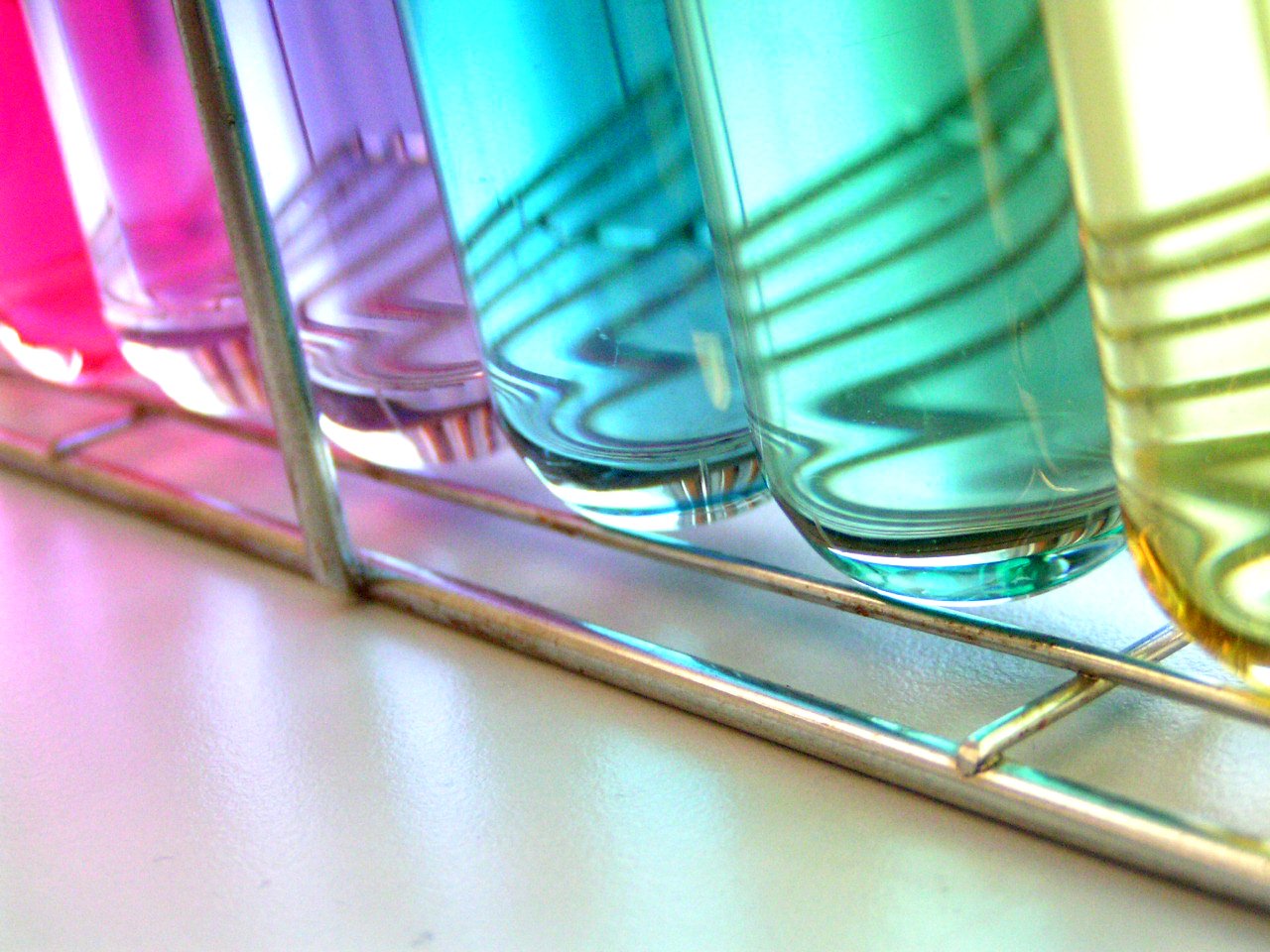 four different colored glass containers are shown in the reflection