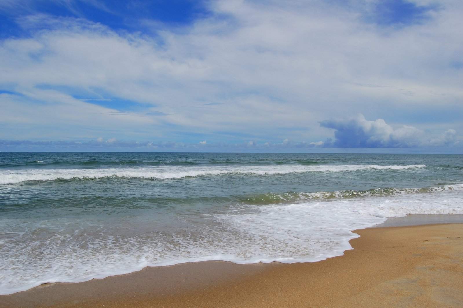 a cloudy day at the beach and water splashing