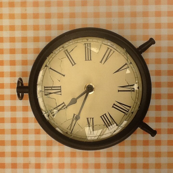 a black clock is against a yellow checkered wall