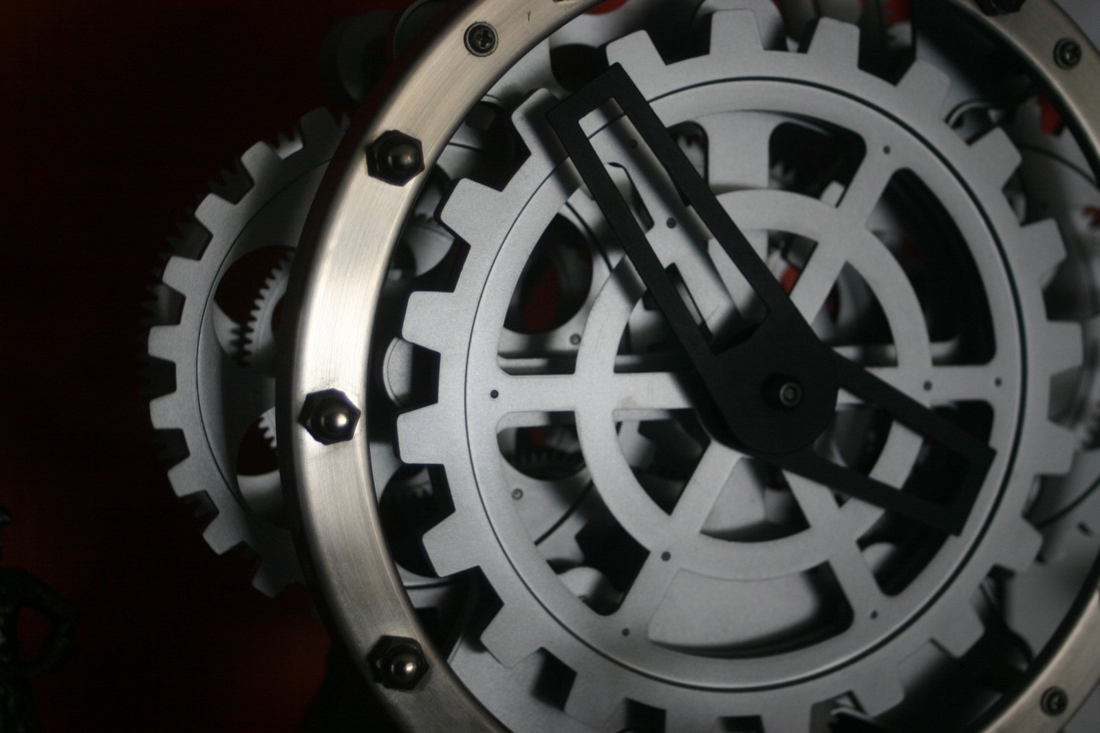 a metal clock with gears in it on a wall
