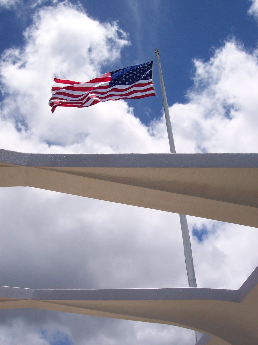 an american flag flies over the top of a large structure