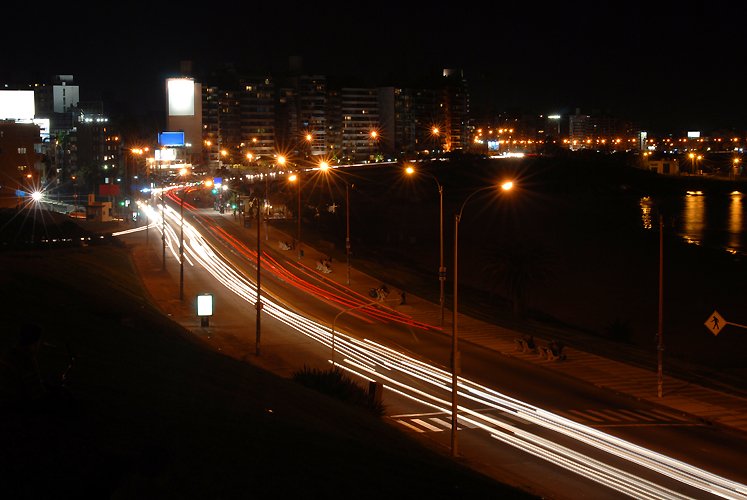 a night view of city lights, on the opposite side of the road