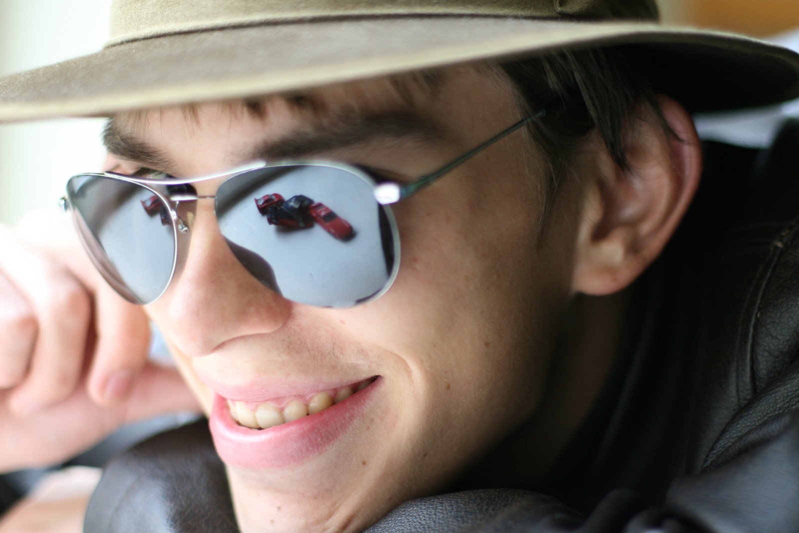 man in sunglasses and hat smiling at camera