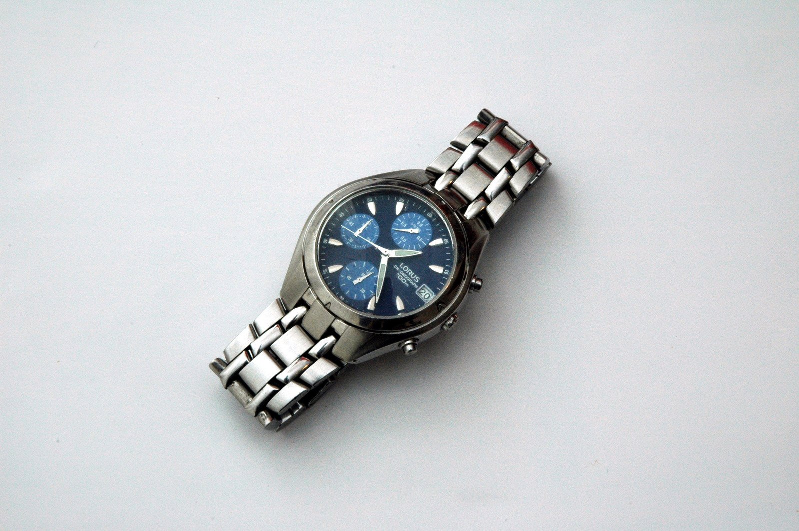 a watch sitting on the ground and silver celets