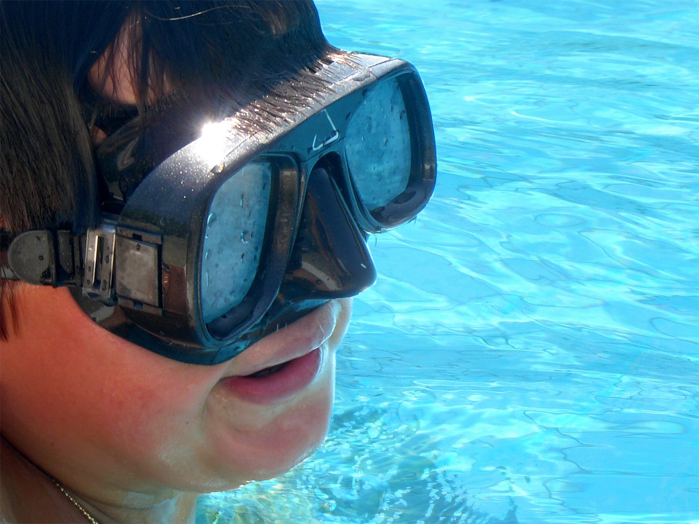 girl wearing goggles, wearing a pair of goggles while swimming in the pool