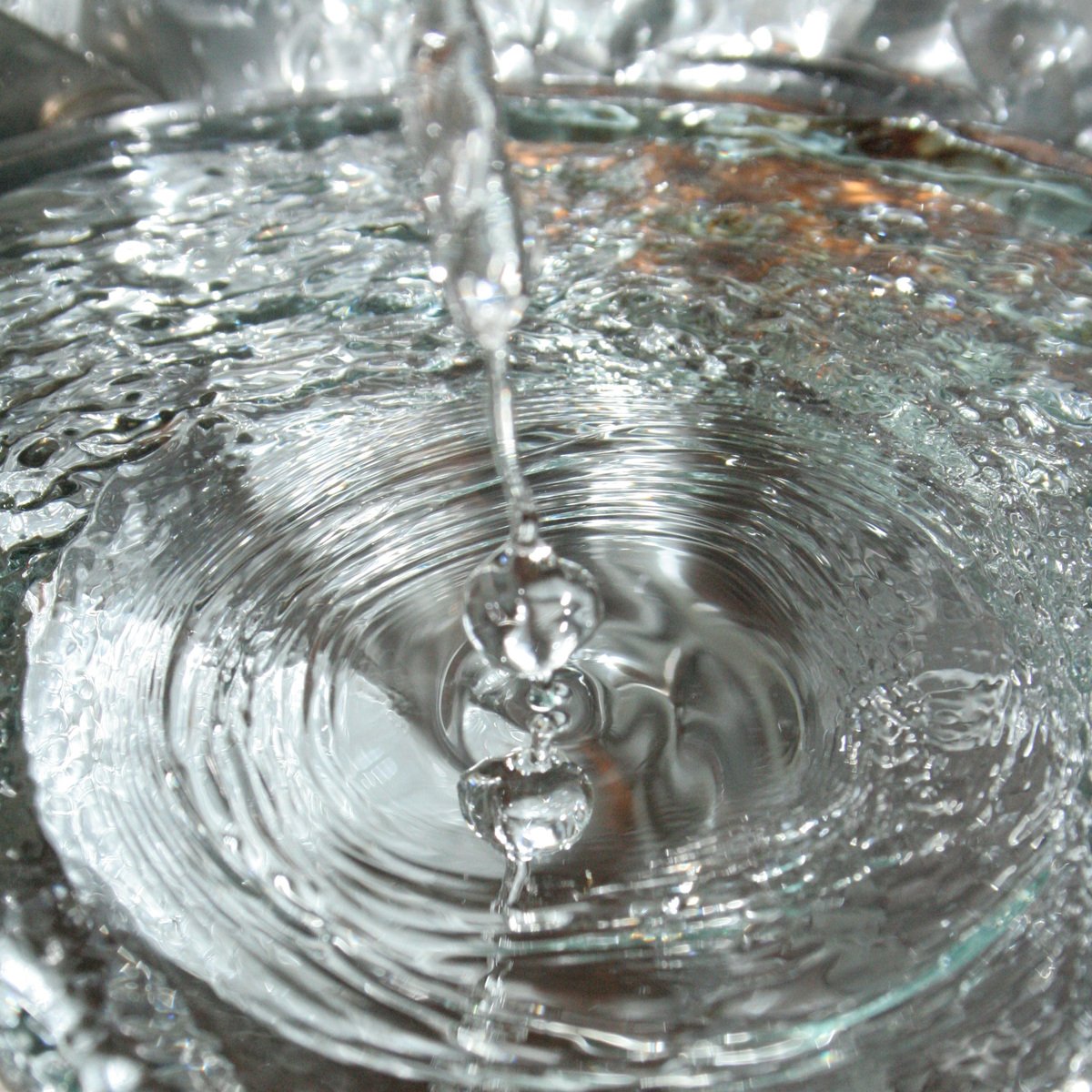 water being poured into a bucket on top of a table