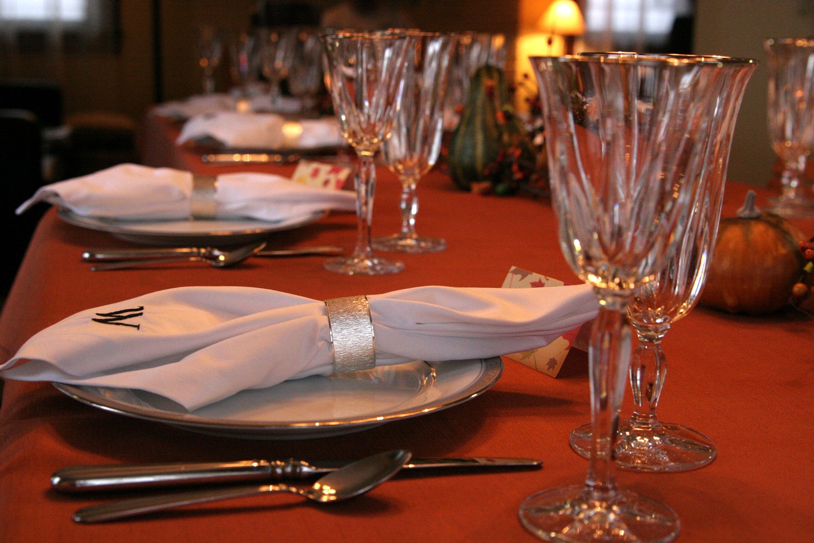 wine glasses, silverware and plates sit on the table