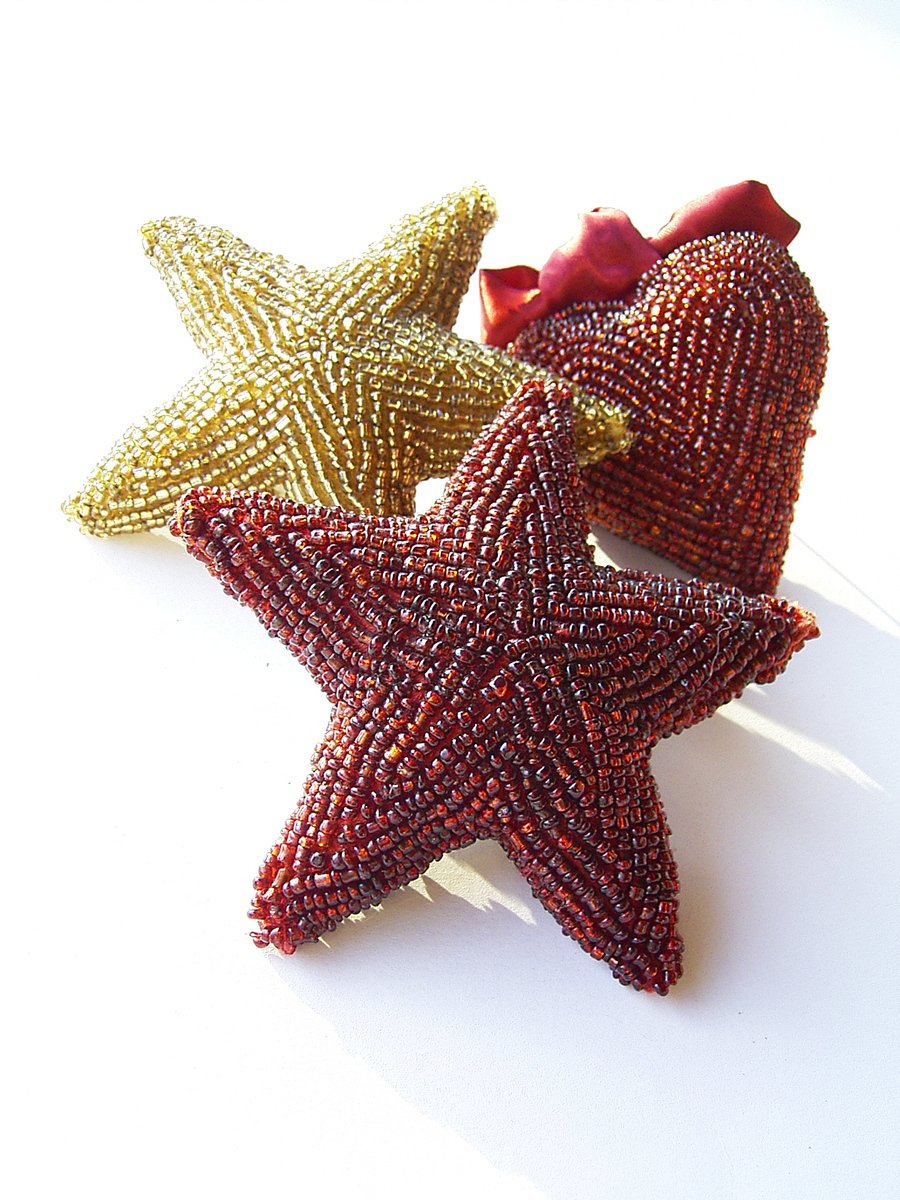 a pair of red and gold star brooches on a white background