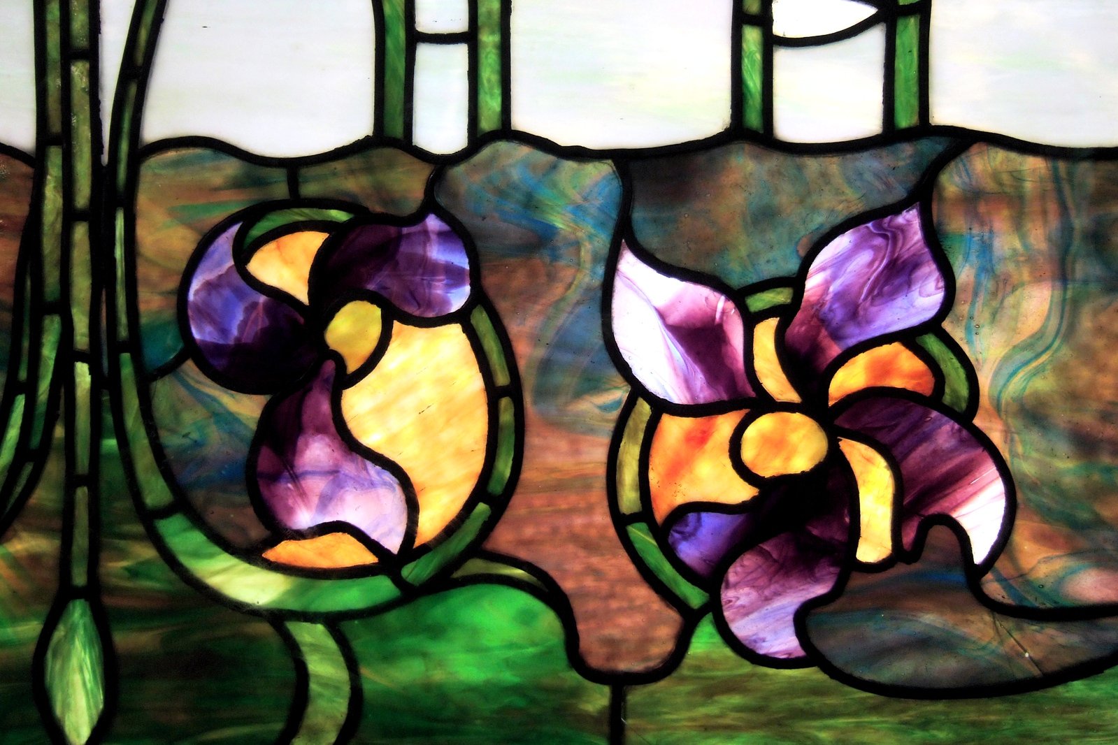 a large stained glass window with flowers on it