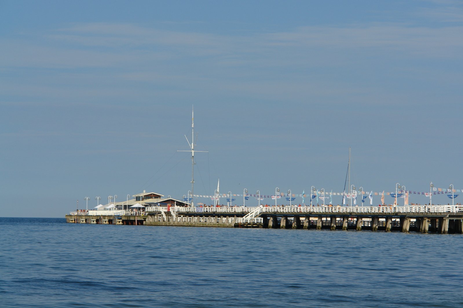 a pier with cars parked at it's end on the water