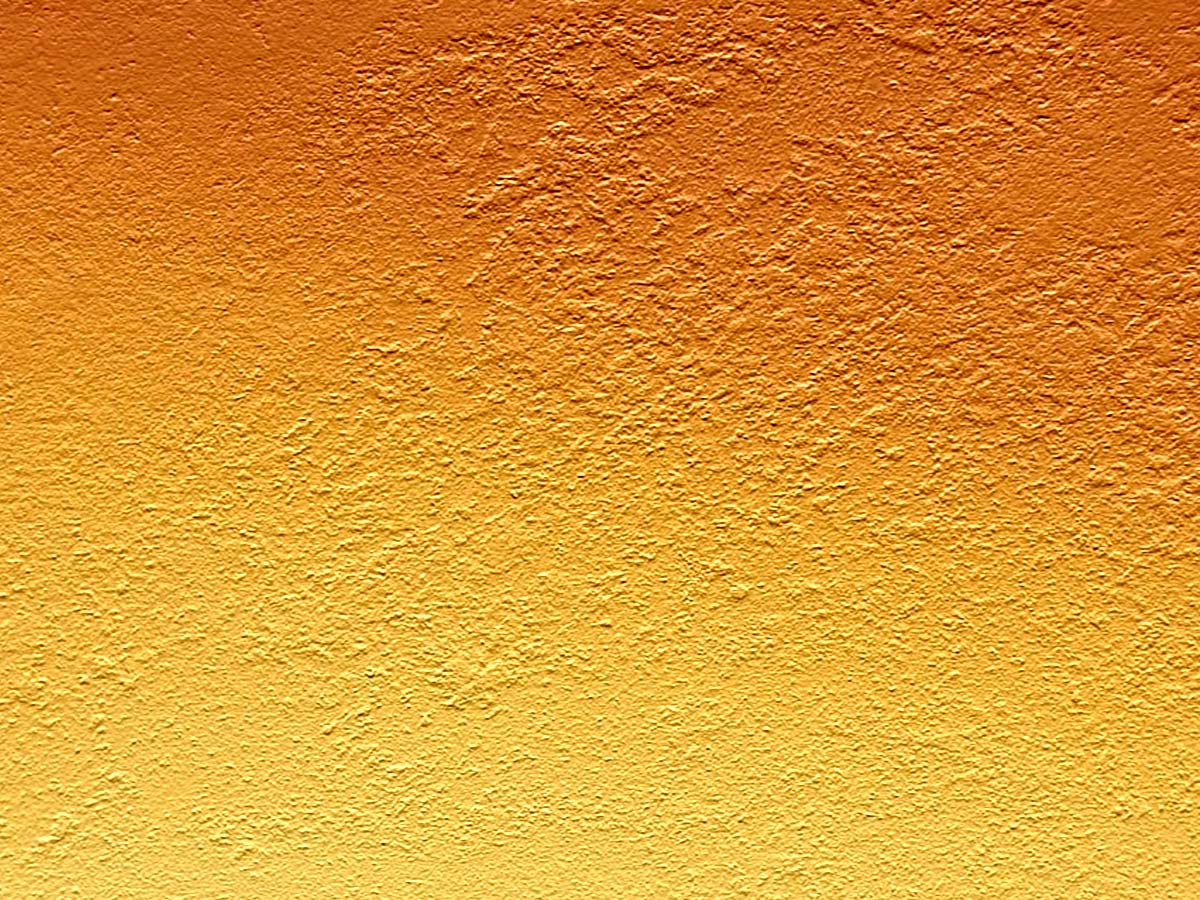 an orange painted wall with yellow and white paint