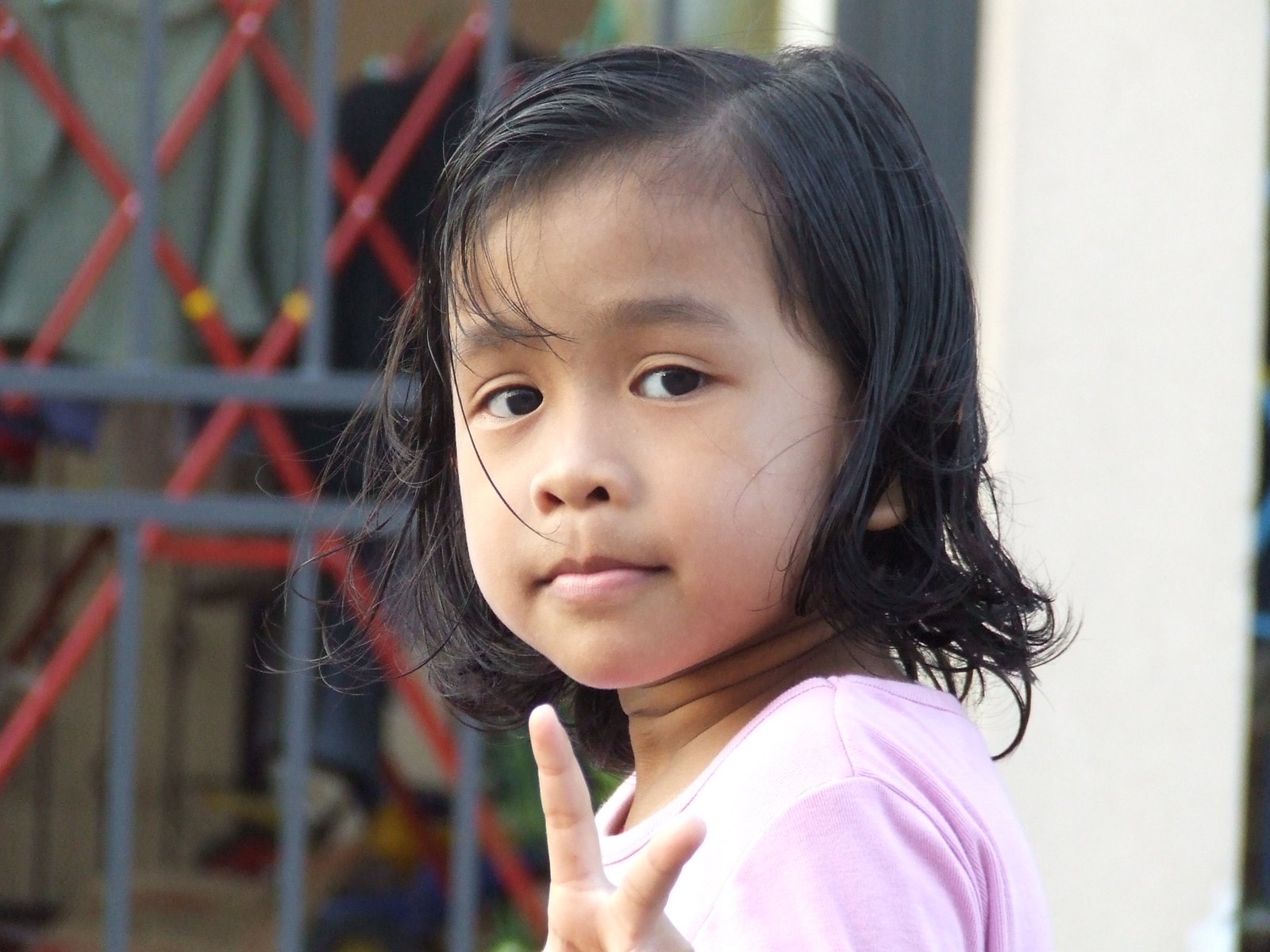 a young asian girl making a peace sign
