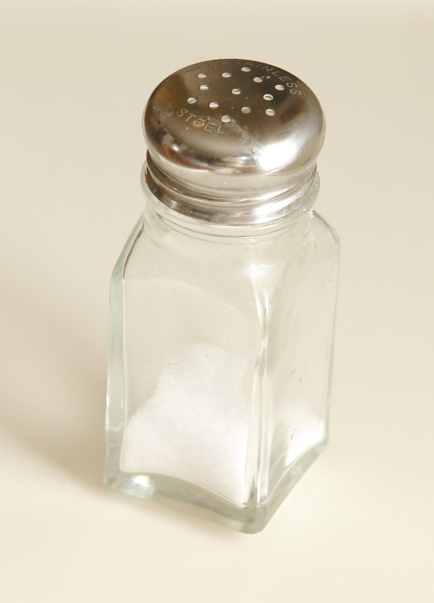 a salt and pepper shaker with a white surface