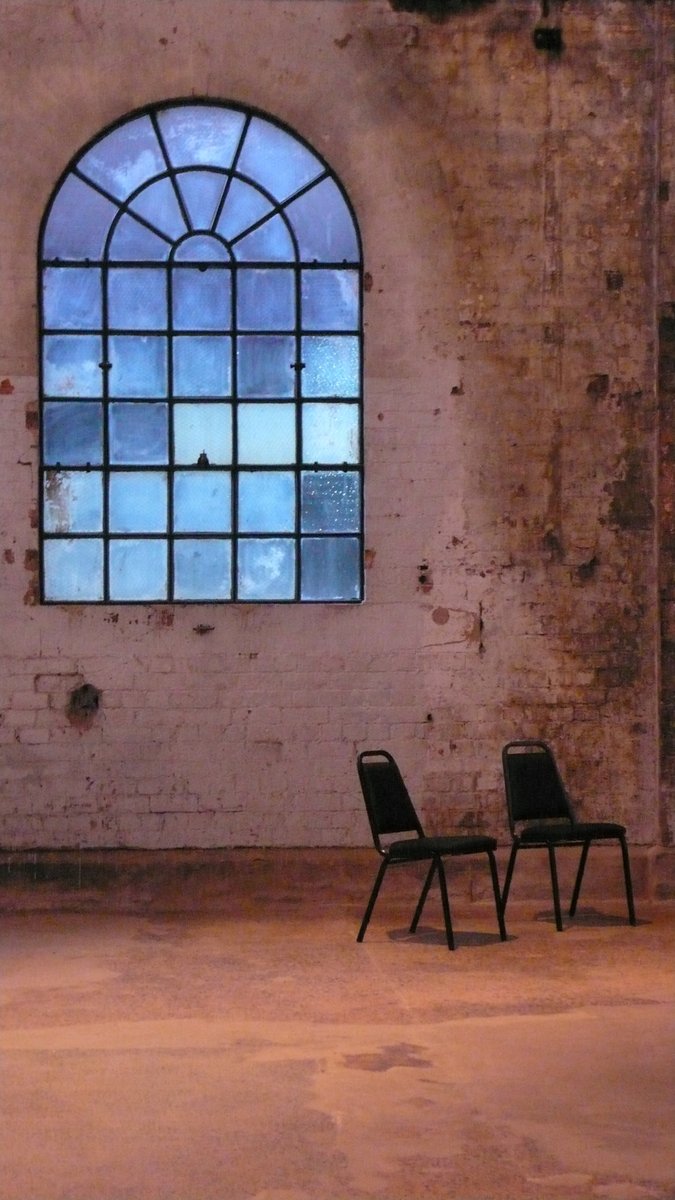two black chairs are in front of a large window