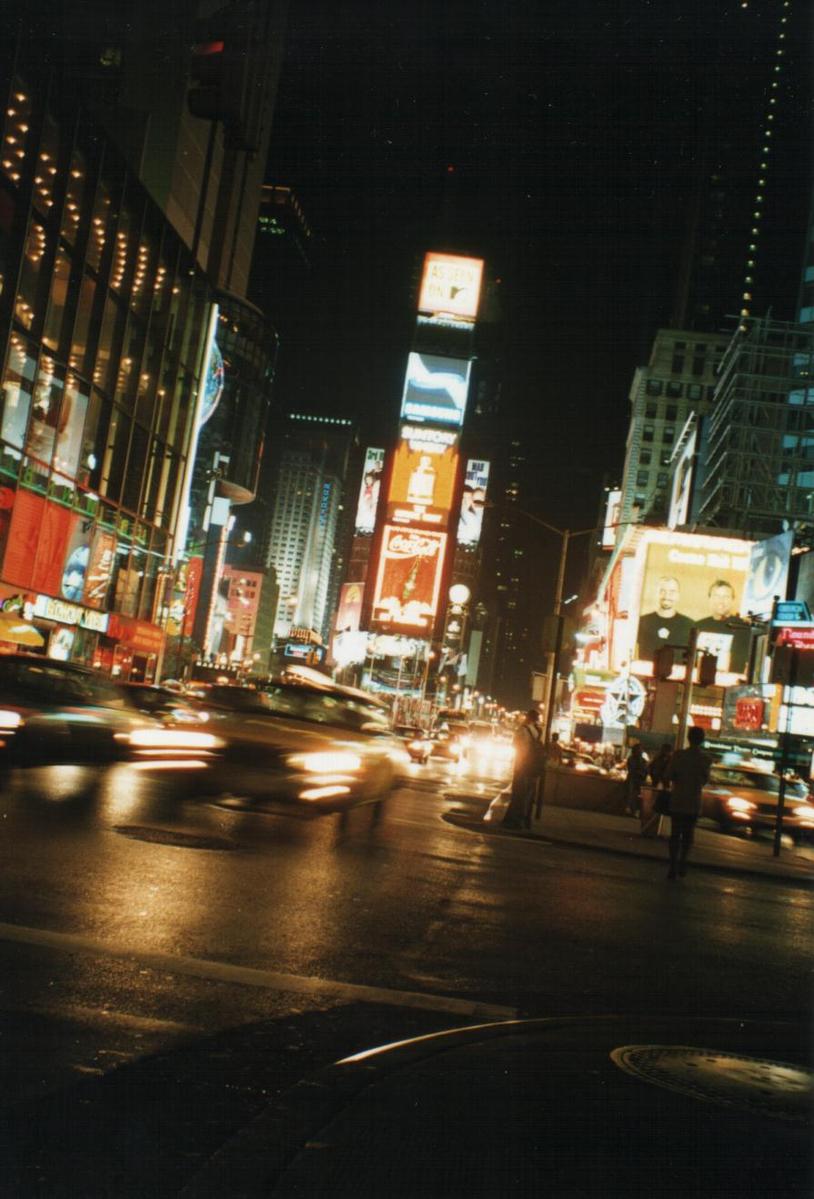 cars at night near the traffic light with many buildings and signs