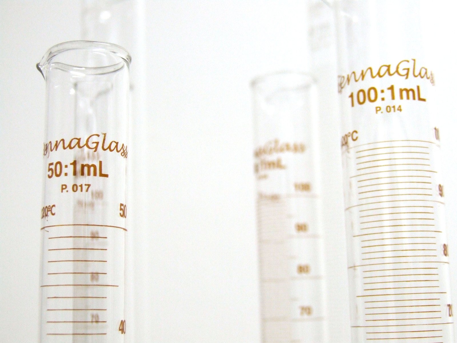 two measuring tubes with clear and brown liquids in them