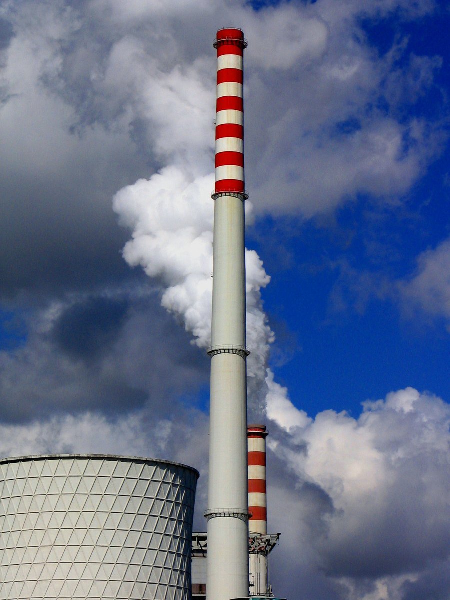 factory chimney with red and white pipes on cloudy day