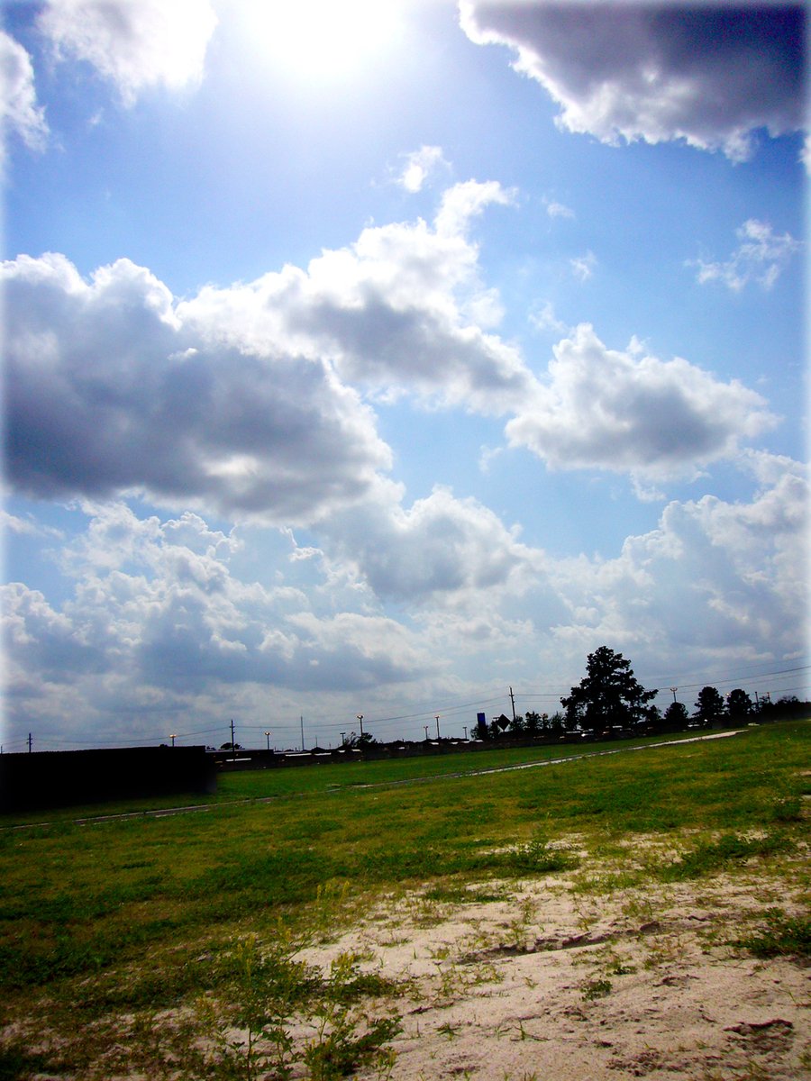 clouds in the sky over a green field