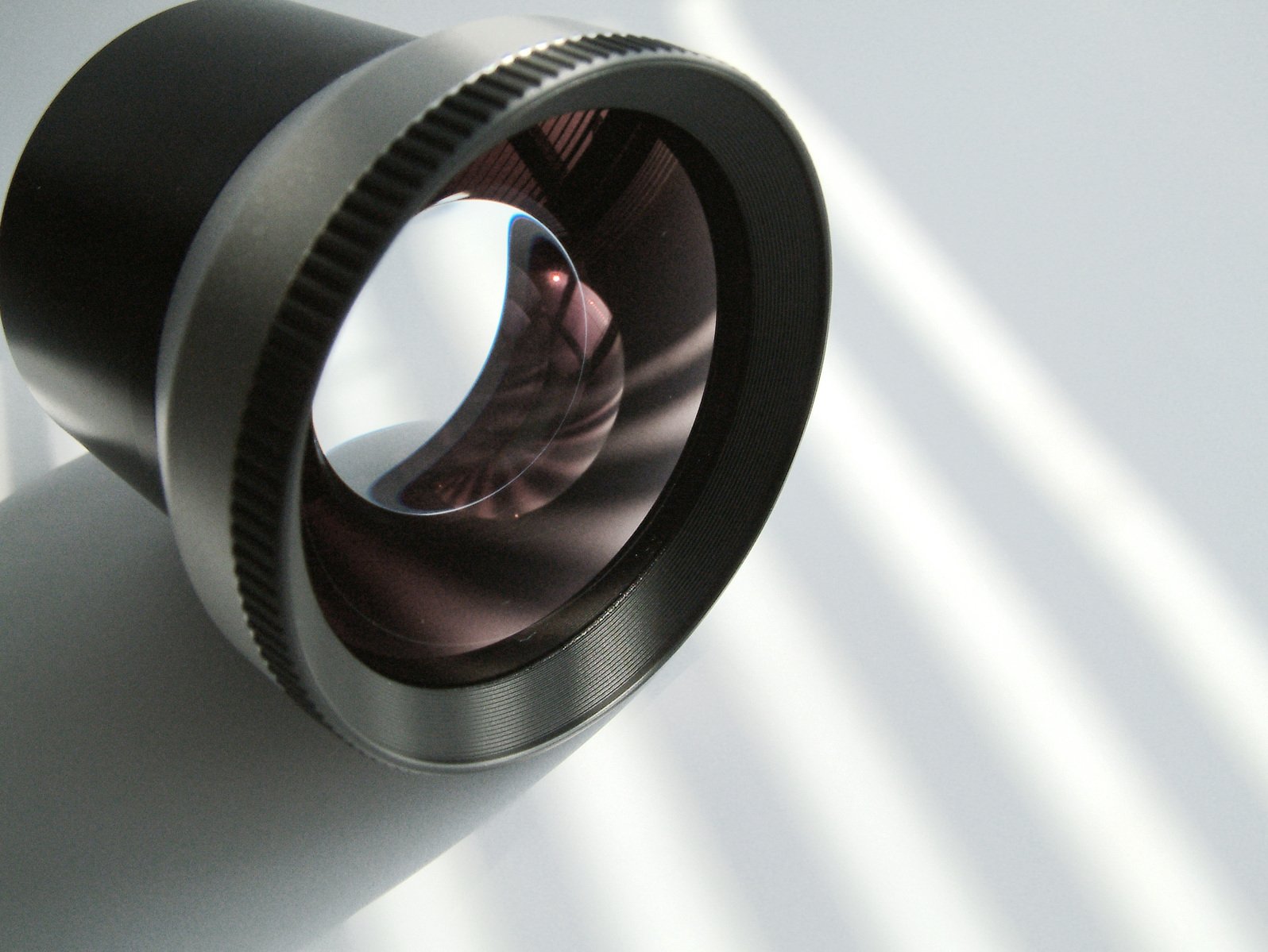 a camera lens laying down on a white table