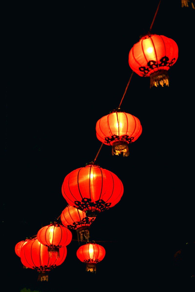 lit lantern in the air at night with lights