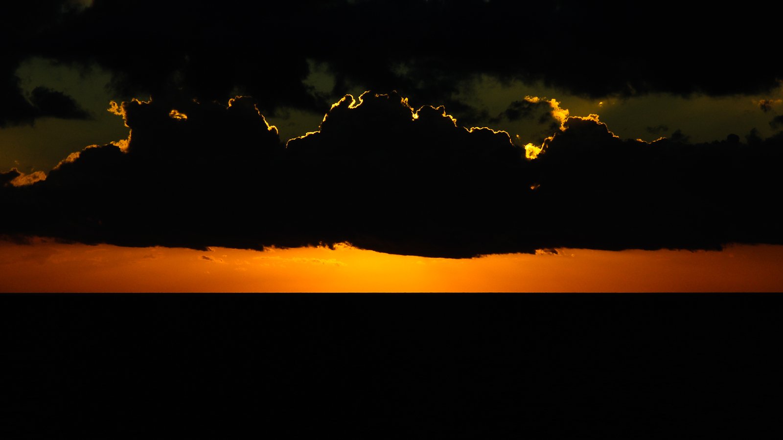 a cloud hangs in front of a black sky