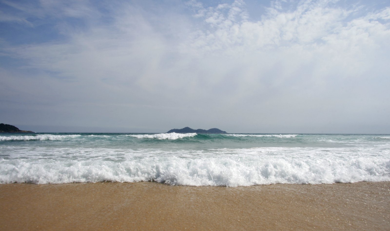 waves lap over the edge of the beach