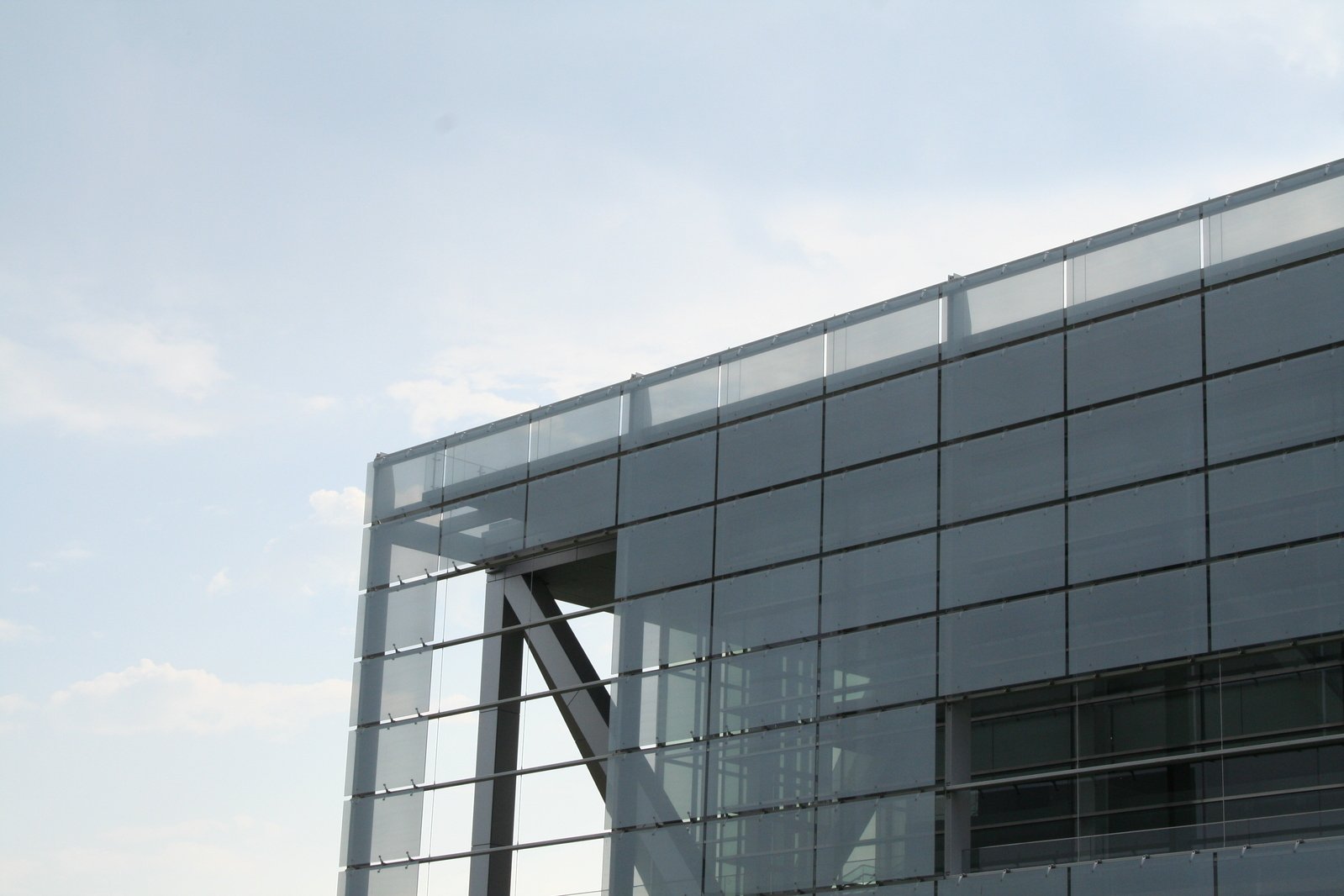 a glass building with a roof and a clock