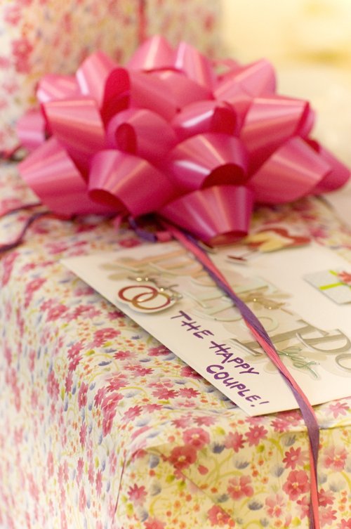 a large gift wrapped in pink ribbon and a tag attached to it