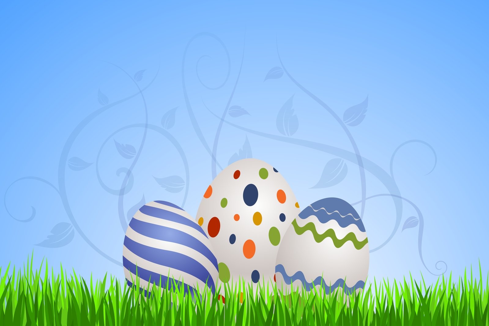 three decorated easter eggs in the grass