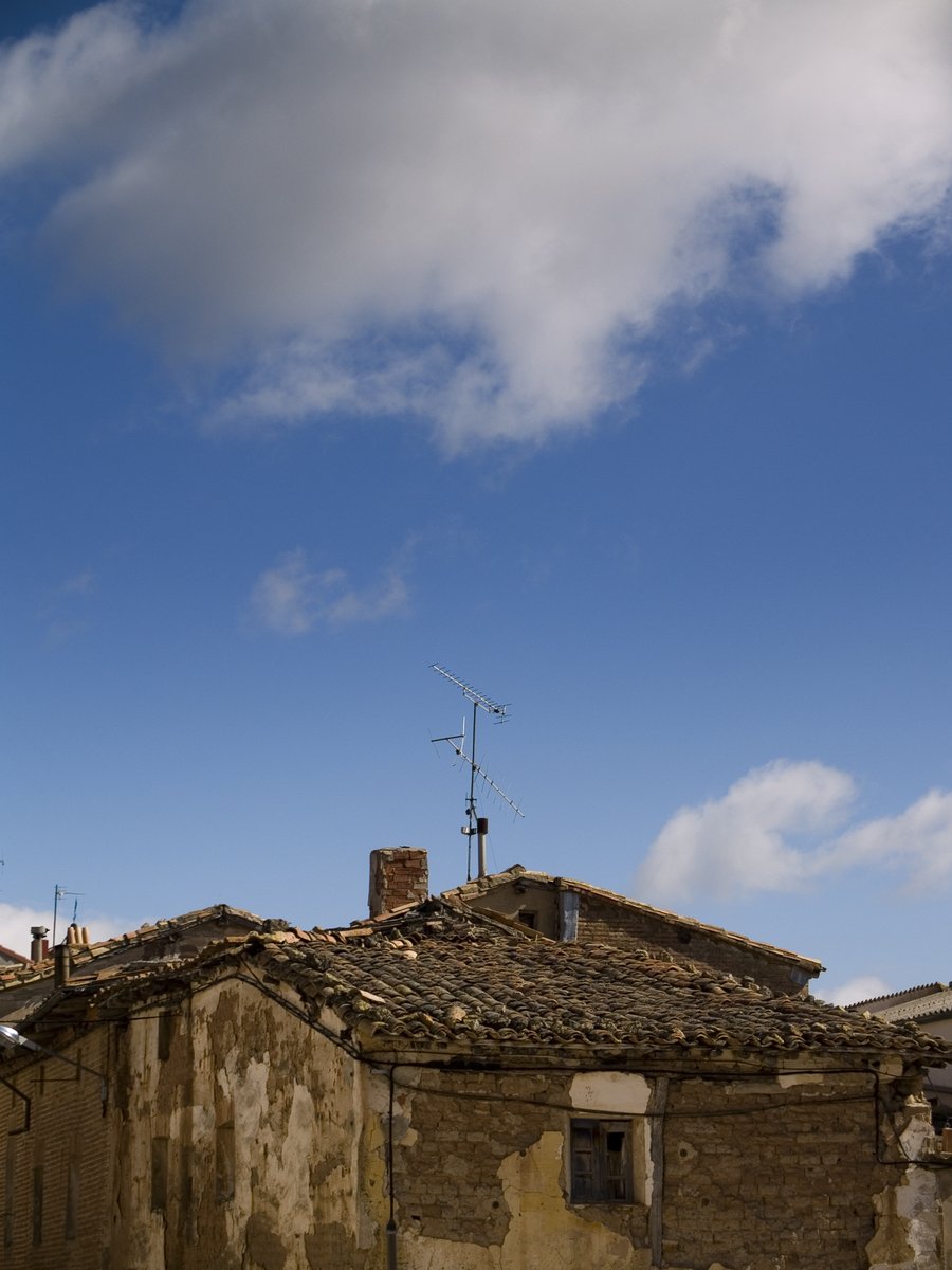 a brick house with some weather vane on the roof