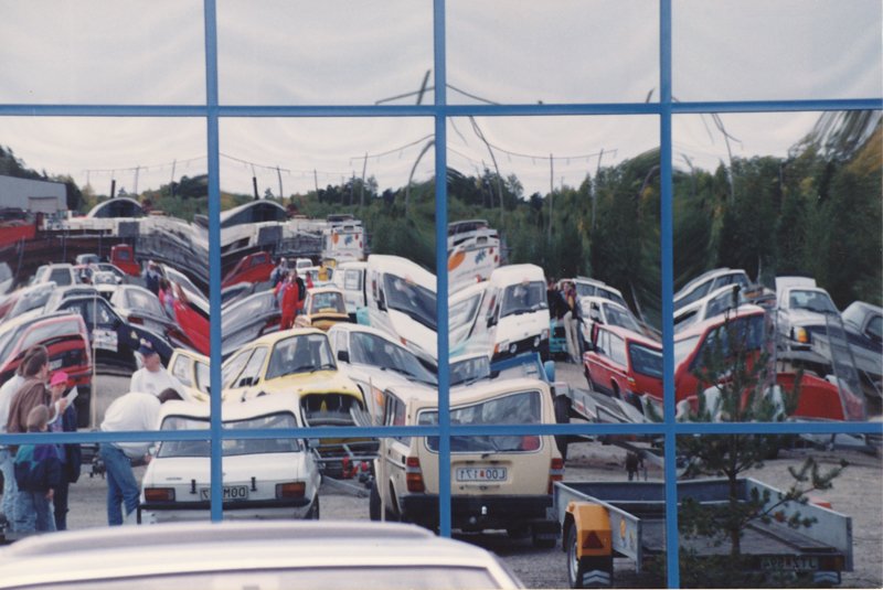 a car park full of white buses parked outside