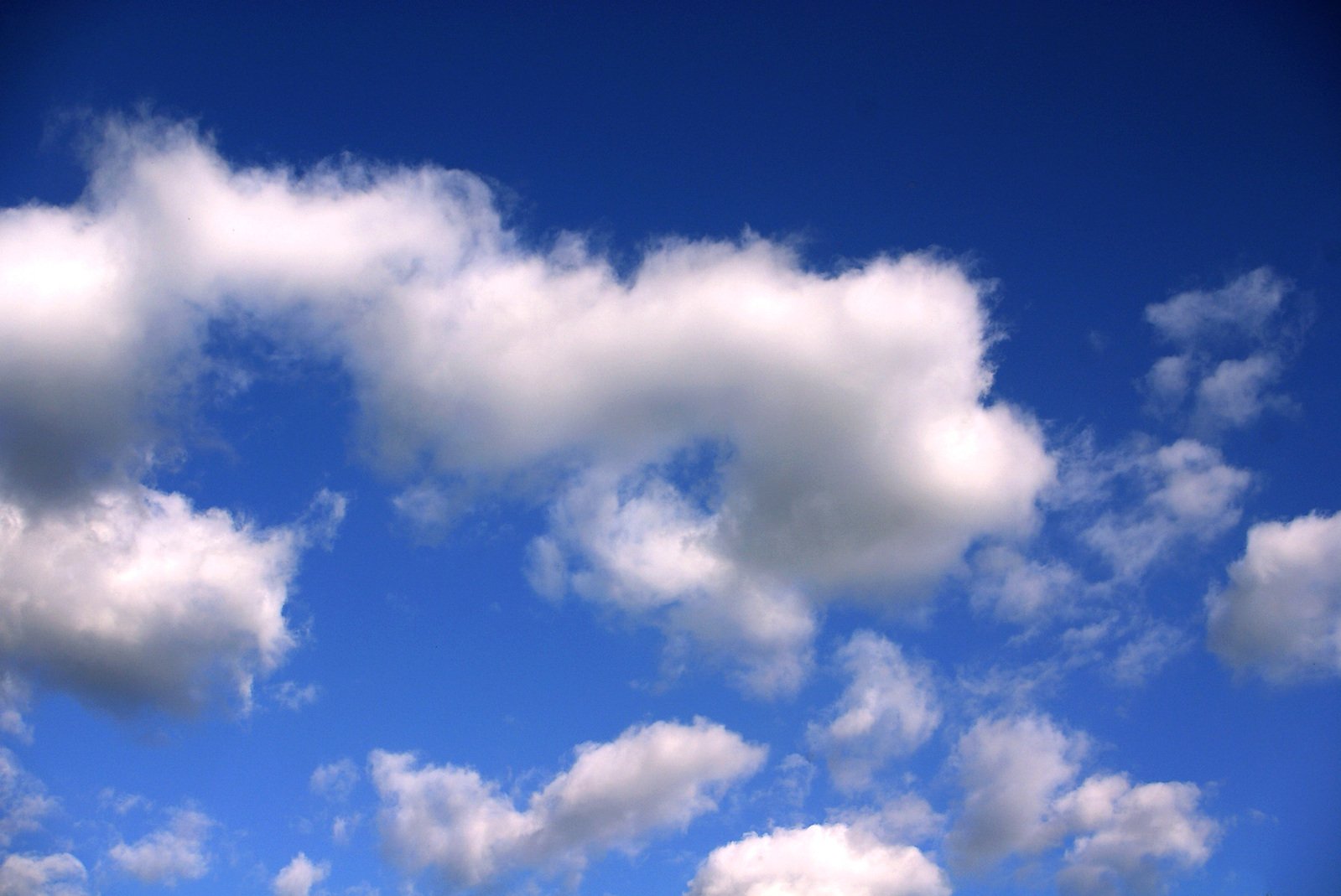 an airplane is flying in the sky with fluffy clouds