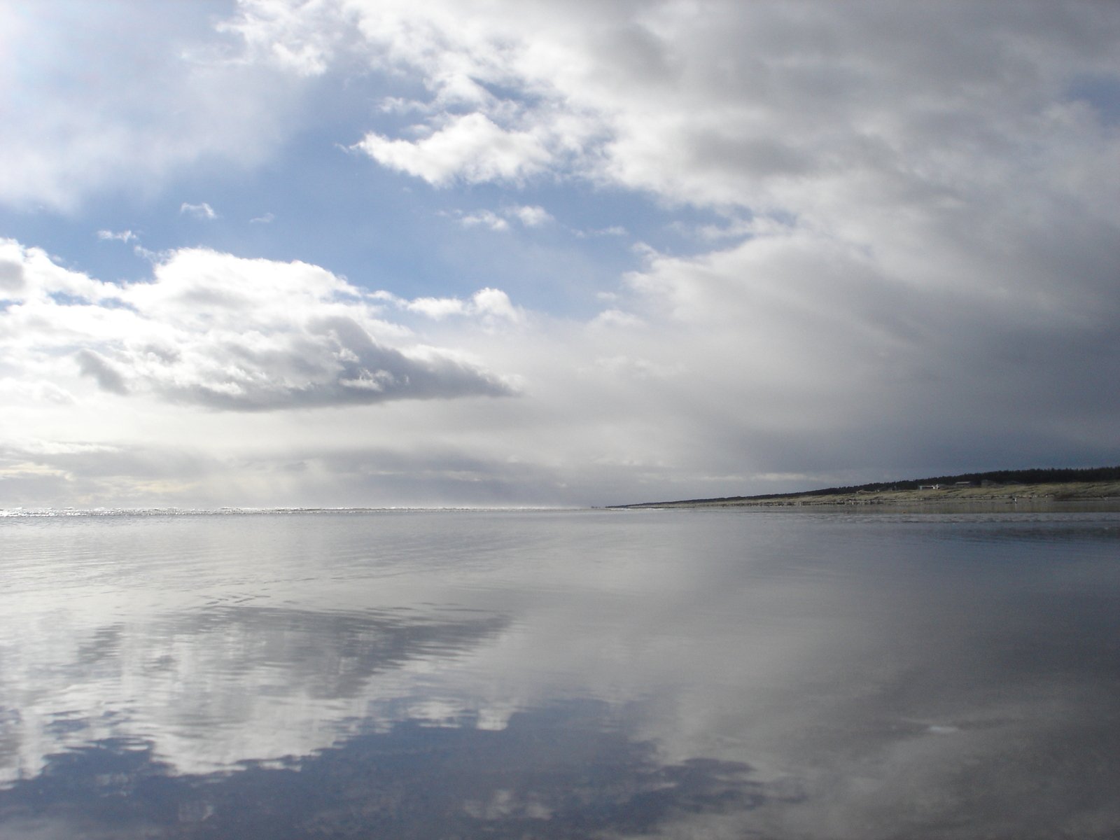 a calm ocean under a cloudy blue sky