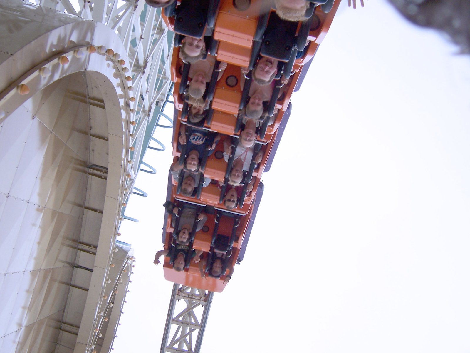 roller coaster ride with riders on top and others sitting in the rail