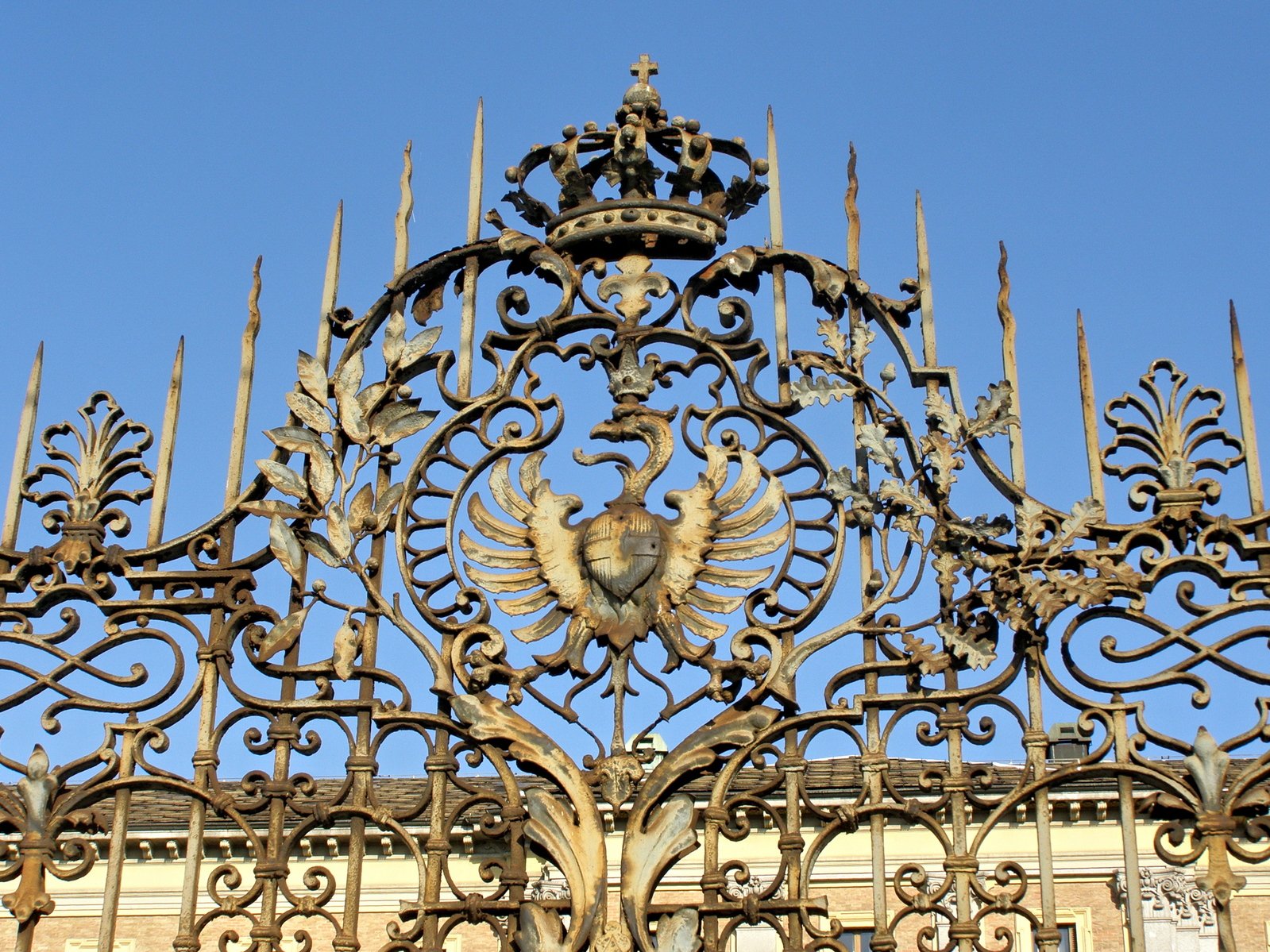 an ornate, iron gate with a decorative bird emblem