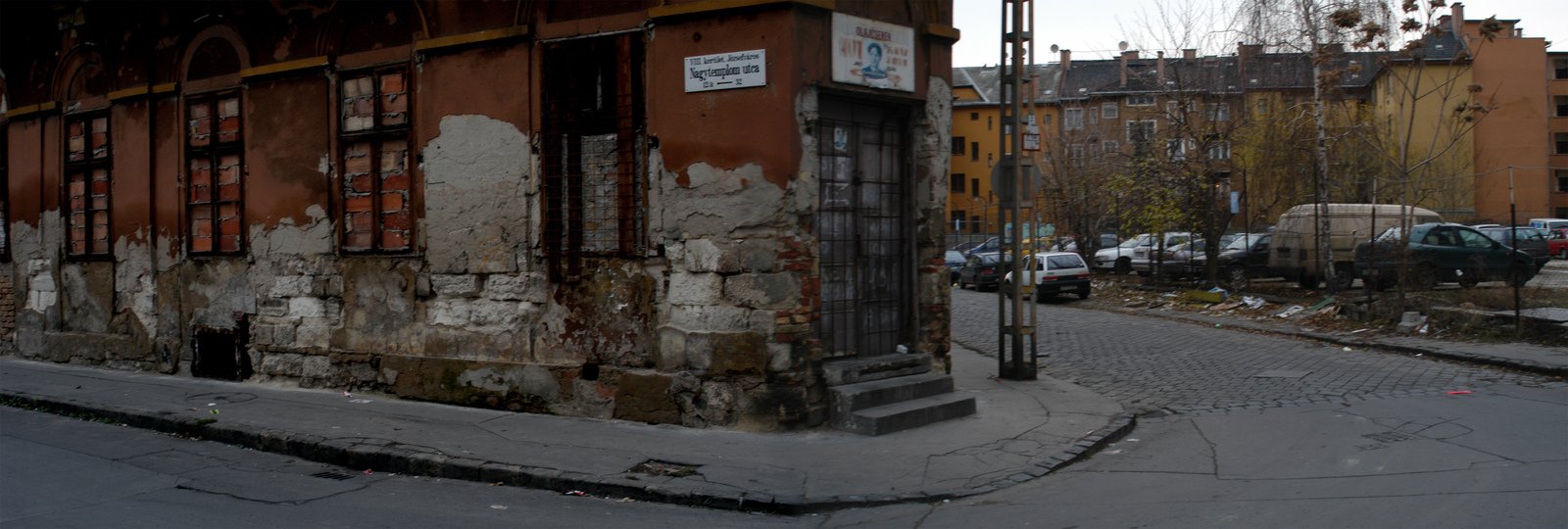 an old building sitting on a corner in the middle of a street