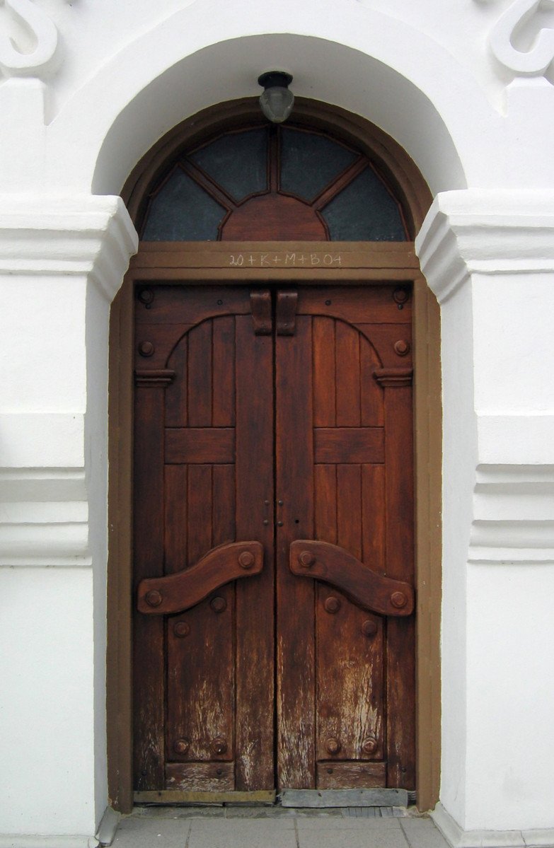 a doorway with two large wooden doors next to a building