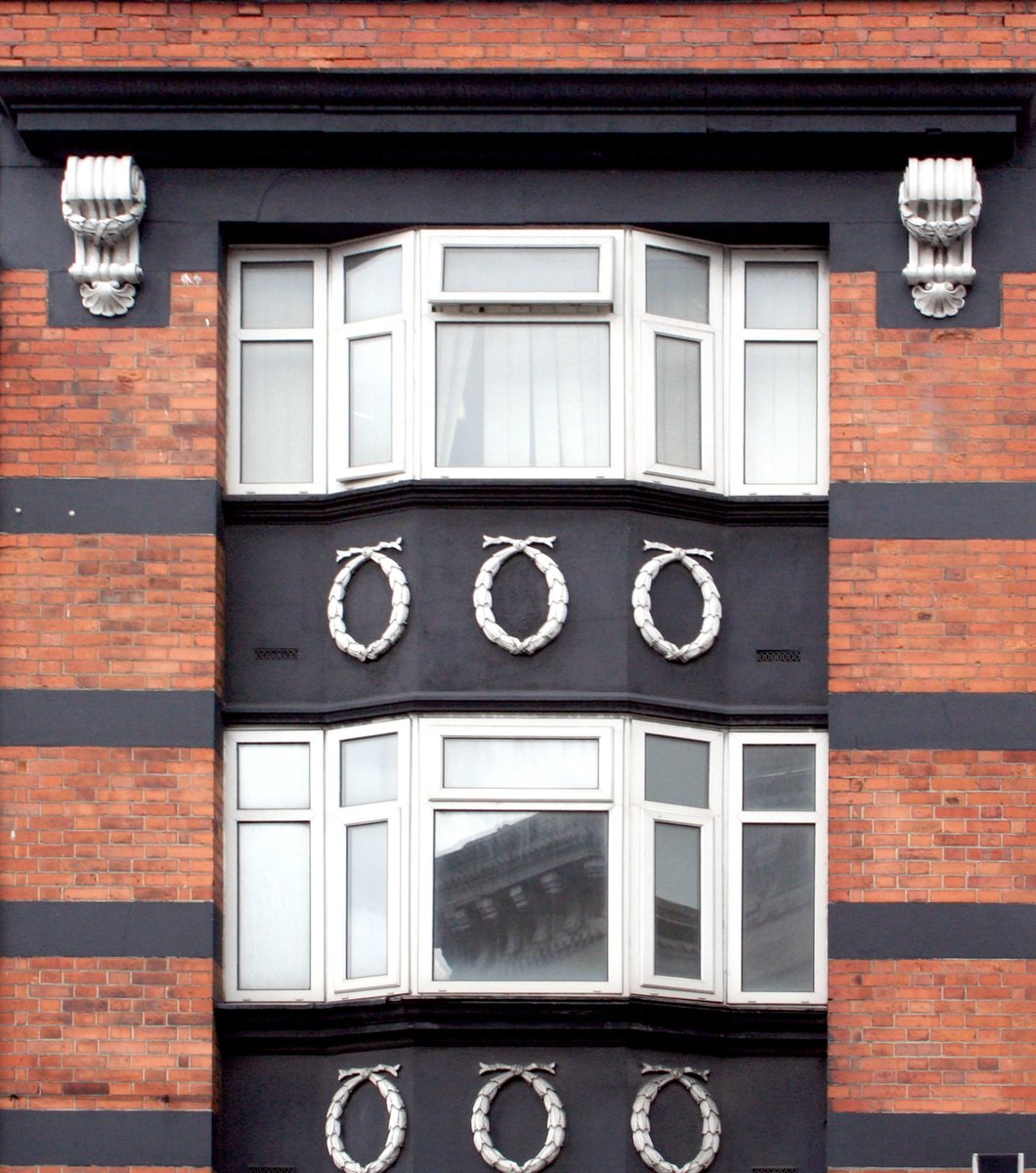 a window with wreaths and mirrors on the outside of a building