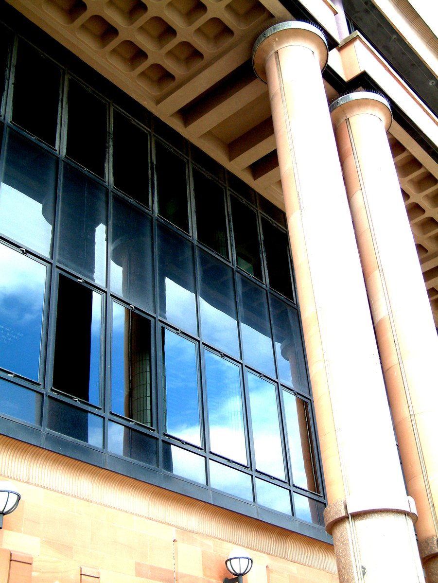 a clock is seen in the windows of a building