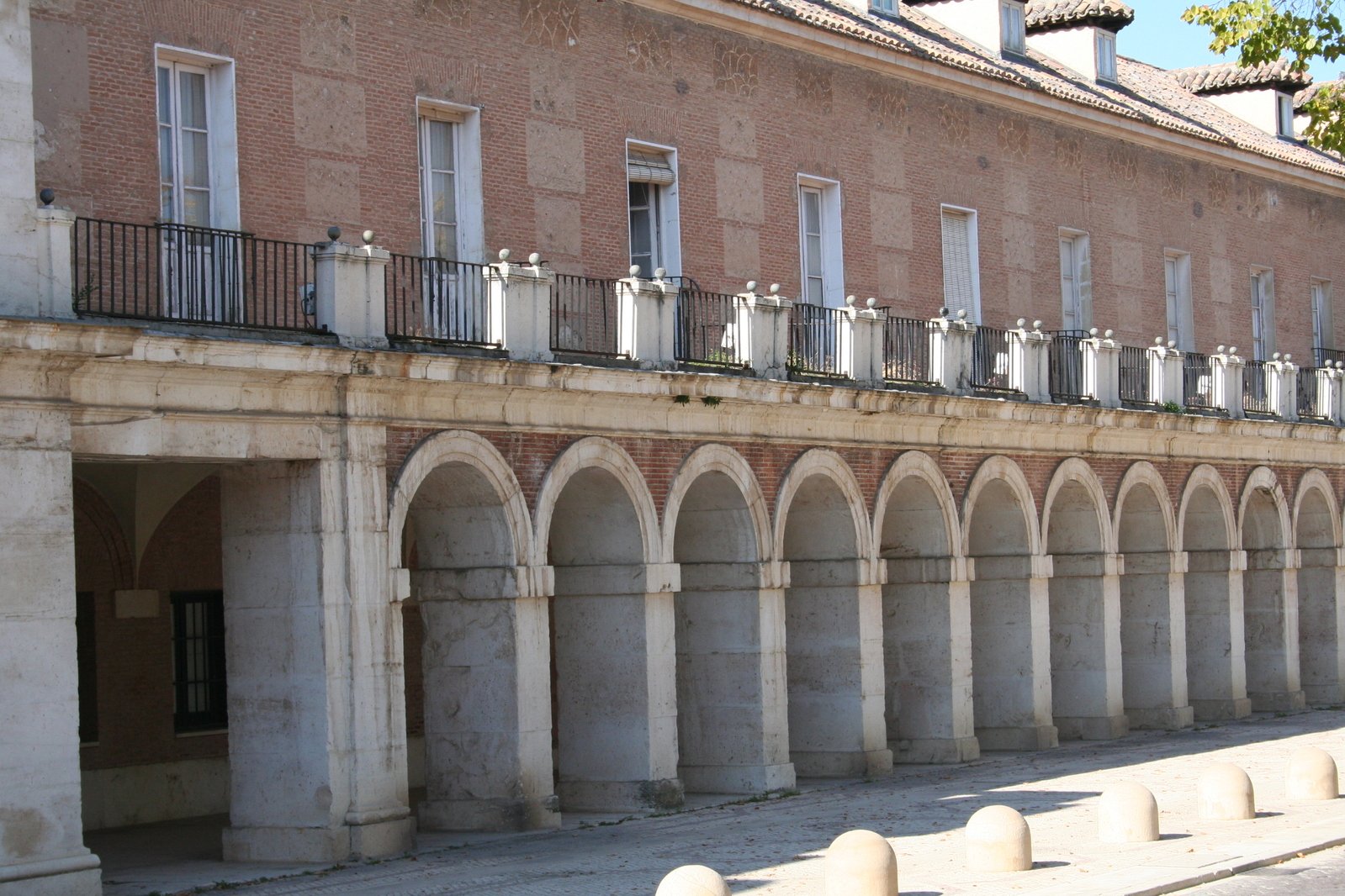 a row of old arches line the side of an old brick building